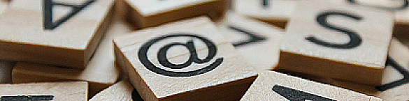 Einige quadratische Holzklötzchen mit Buchstaben und einem et-Zeichen