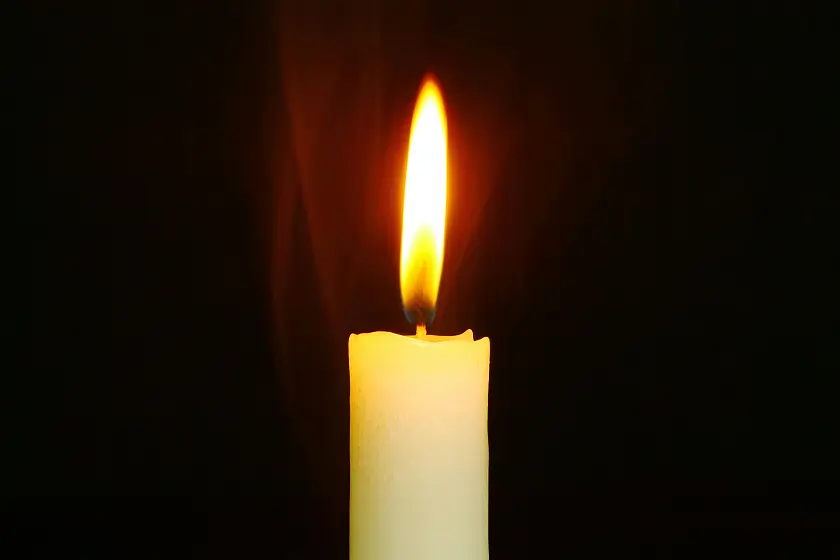 Eine Kerzenflamme vor dunklem Hintergrund