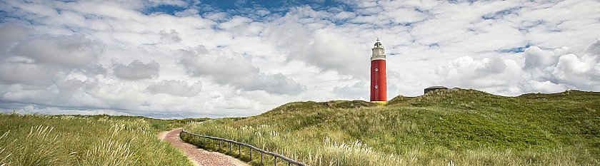 Grüner Deich mit blauem Himmel, Wolken und Leuchtturm