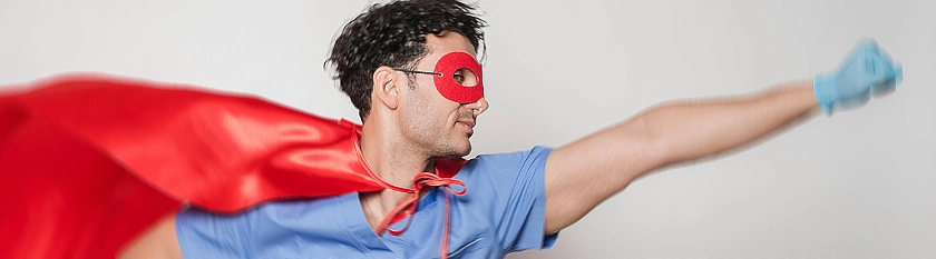 Mann im Supermannkostüm mit blauem Gummihandschuh und nach vorne gestrecktem Arm